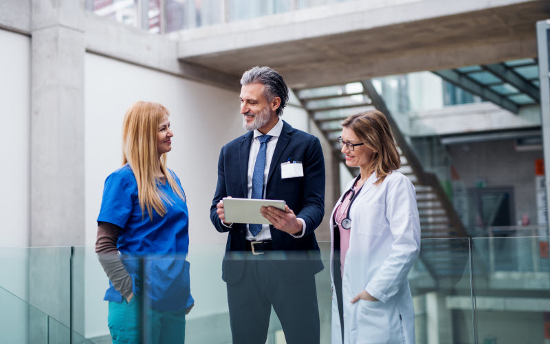 Group of doctors talking to pharmaceutical sales representative.